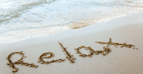 Relax written in beach sand